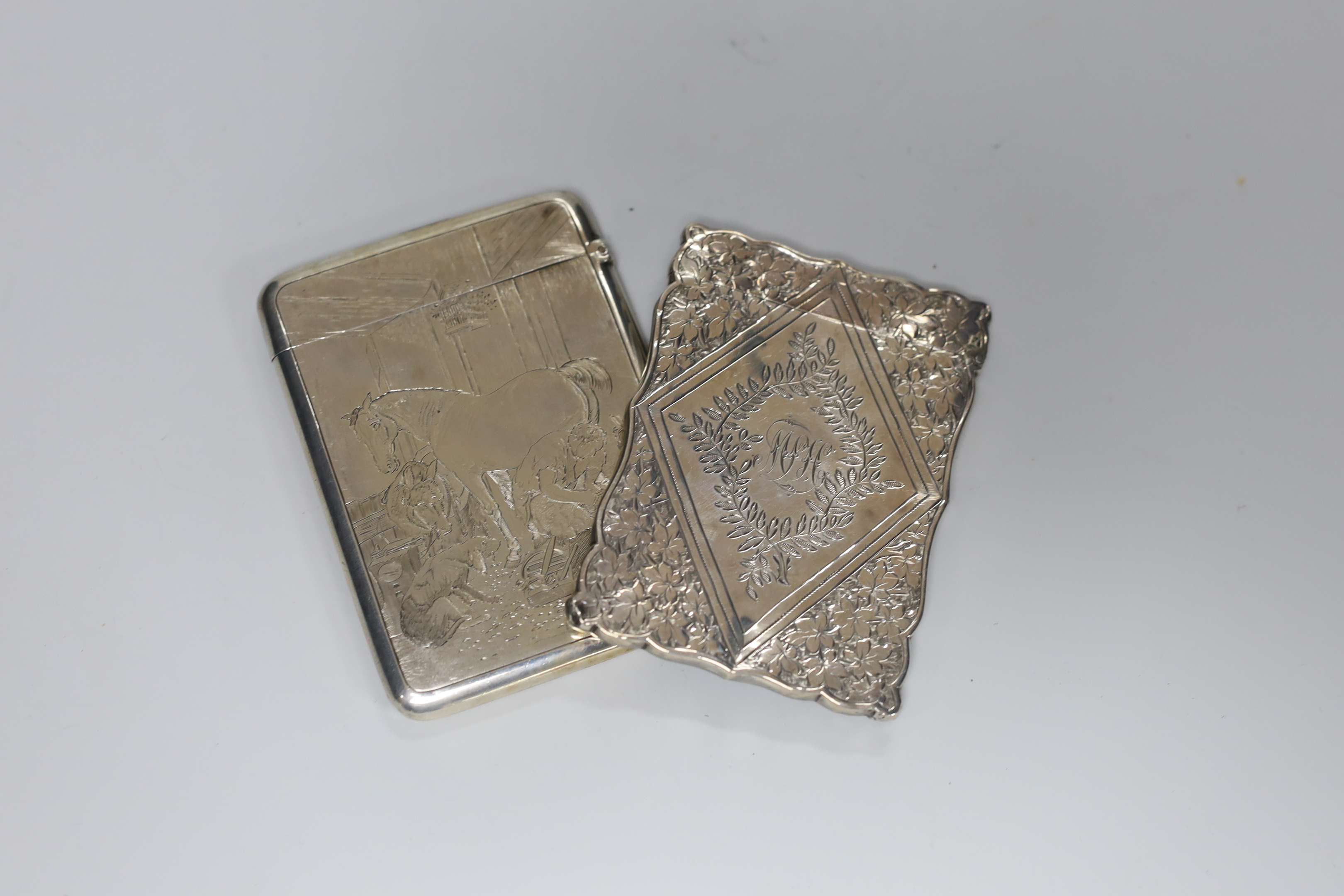 Two Victorian silver card cases, one engraved with farrier in a barn, B.H. Joseph & Co, Chester, 1880, 93mm, the other with foliate decoration, by Levi & Salaman.